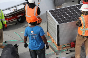 unloading pallets of solar panels on roof