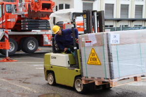 unloading the solar panels from the truck before they are hoisted up by the crane